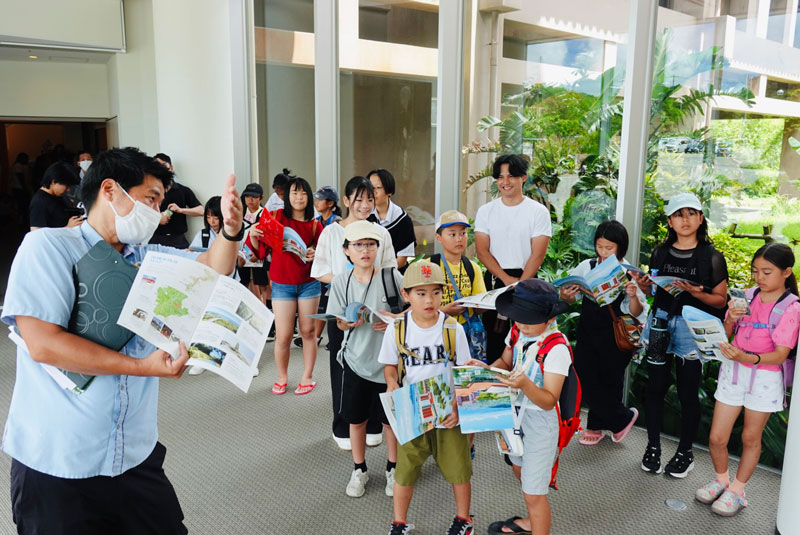 施設の説明を聞く子供達の写真