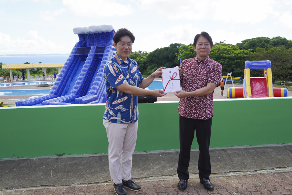 施設無料券を贈呈する柏倉総支配人（左）と具志堅教育長